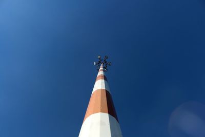 Low angle view of weather vane against clear blue sky