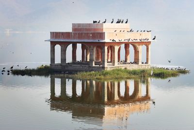 Built structure in lake against sky