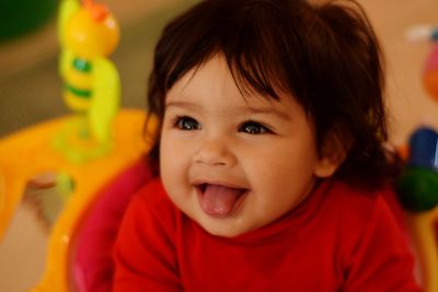 Close-up of cute baby girl sticking out tongue at home