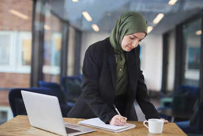 Woman in office taking notes