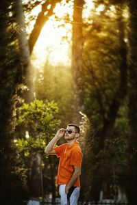 Man standing by tree in forest