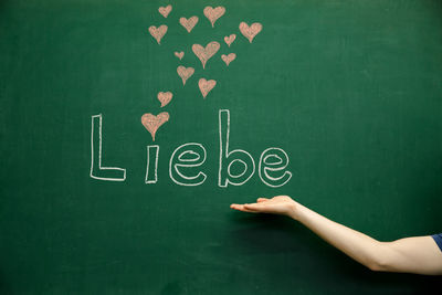 Cropped image of person against blackboard with german text