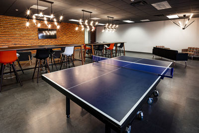 Empty chairs and tables in illuminated room