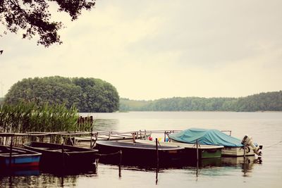 Boats moored in lake against sky