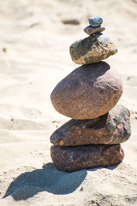 Close-up of stone stack on sand at beach