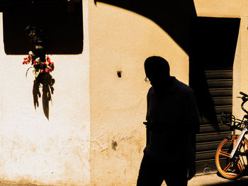 Rear view of man standing against wall in building