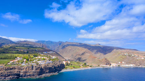 Scenic view of sea and mountains against sky