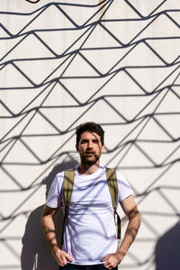 Portrait of handsome man standing by wall