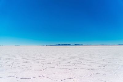 Scenic view of desert against clear blue sky