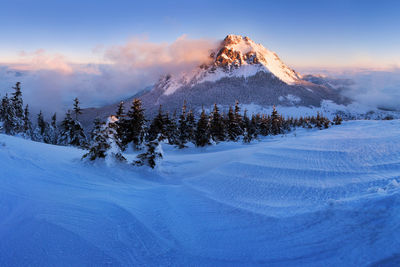 Scenic view of snow covered mountains against sky