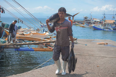 Men standing on shore against sky