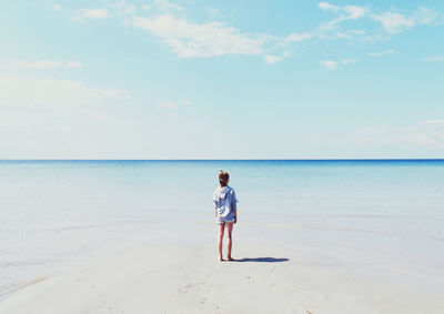 Full length of man standing on beach against sky