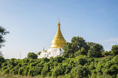 Close-up of pagoda against blue sky and trees