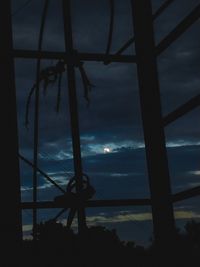 Low angle view of silhouette electricity pylon against sky at sunset