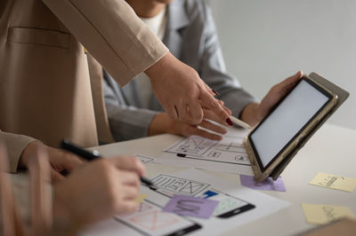 Midsection of business colleagues working on table