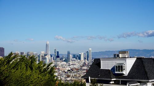 Buildings in city against blue sky