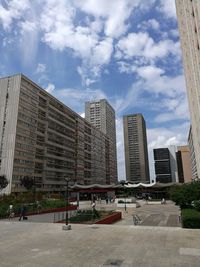 Modern buildings against cloudy sky