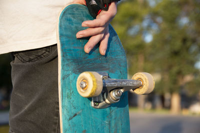 Close-up of skateboarder holding his skateboard