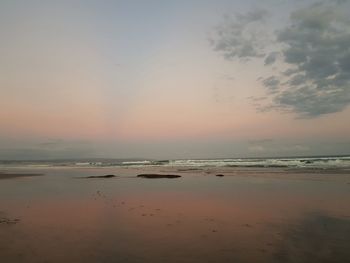 Scenic view of beach against sky during sunset