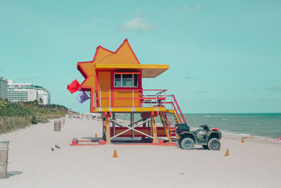 Lifeguard hut on beach by sea against sky