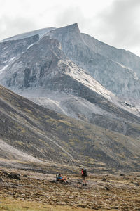 People on snowcapped mountain against sky