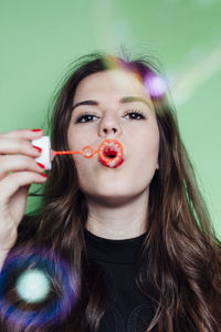 Portrait of young woman blowing bubbles