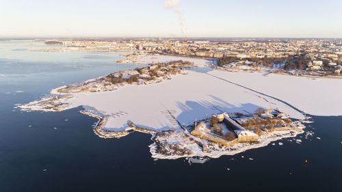 High angle view of city by sea against sky