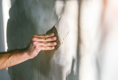 Cropped hand of worker plastering wall