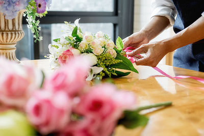 Midsection of woman holding flowering plant