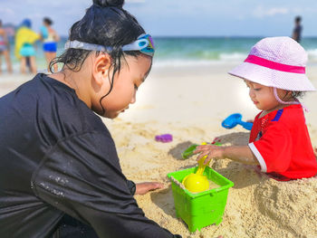 Sisters playing on sand at beach