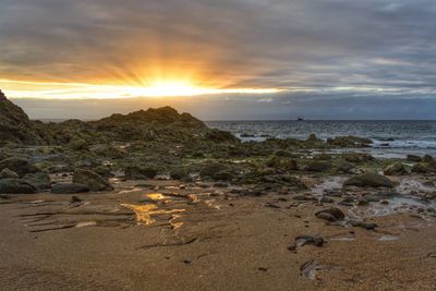 Scenic view of beach against sky during sunset