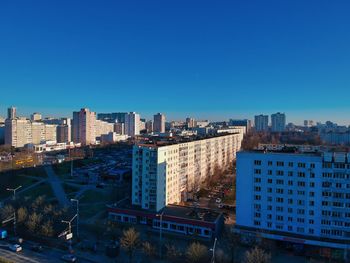 High angle view of buildings against clear blue sky