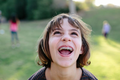 Girl with braces makes a silly face while looking up at sky