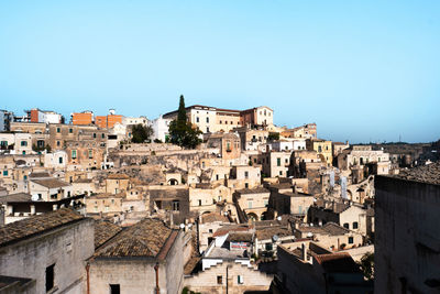 Houses in town against clear blue sky