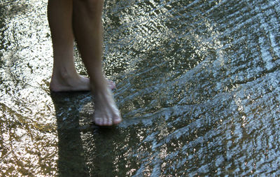 Low section of woman standing in water