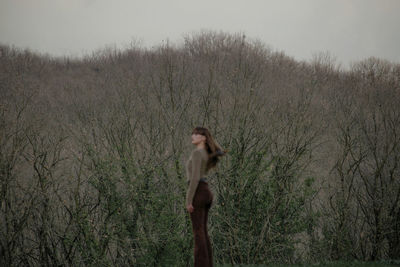 Rear view of a woman standing in the forest