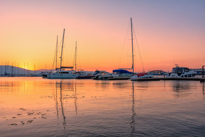 Sailboats in sea at sunset