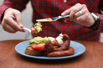 Midsection of man having food at table