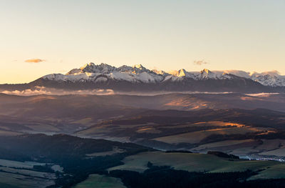 Scenic view of snowcapped mountains against sky during sunset