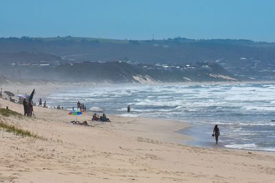 People on beach against sky