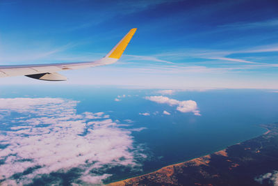 Cropped image of airplane flying over clouds