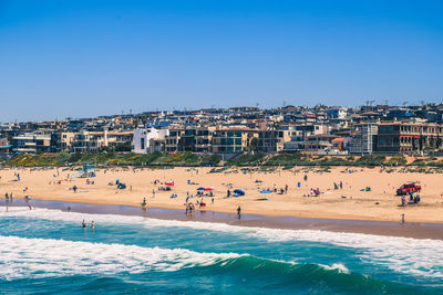 High angle view of people at beach against clear blue sky