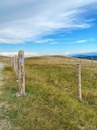 Wooden fence on field against sky