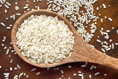 Close-up of rice in wooden spoon on table