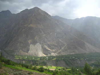 Scenic view of mountain range against cloudy sky