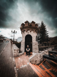 Man standing by built structure against sky