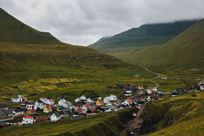 Scenic view of field and buildings against sky