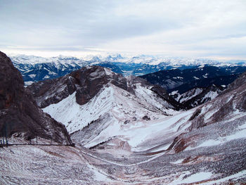 Aerial view of snowcapped mountains against cloudy sky