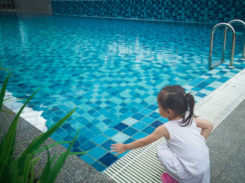 Little asian toddler baby have a fun with a splash near swimming pool