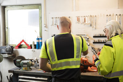 Male and female colleagues working in workshop